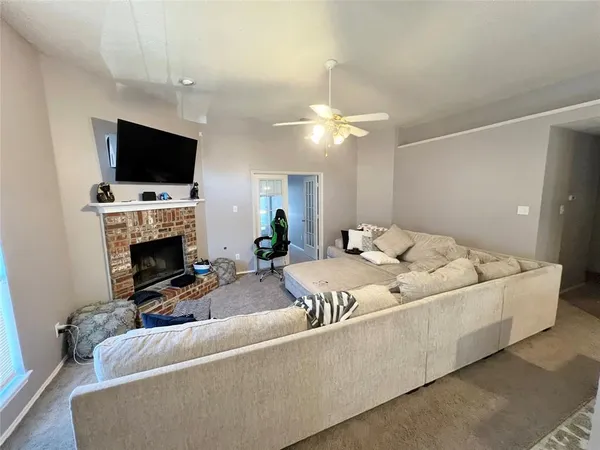 a living room with furniture a flat screen tv and a fireplace