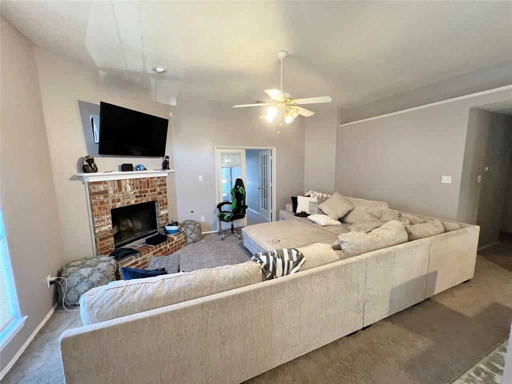 112 Walnut Lane Rockwall, TX 75032 - Photo 5 of 19 a living room with furniture a flat screen tv and a fireplace