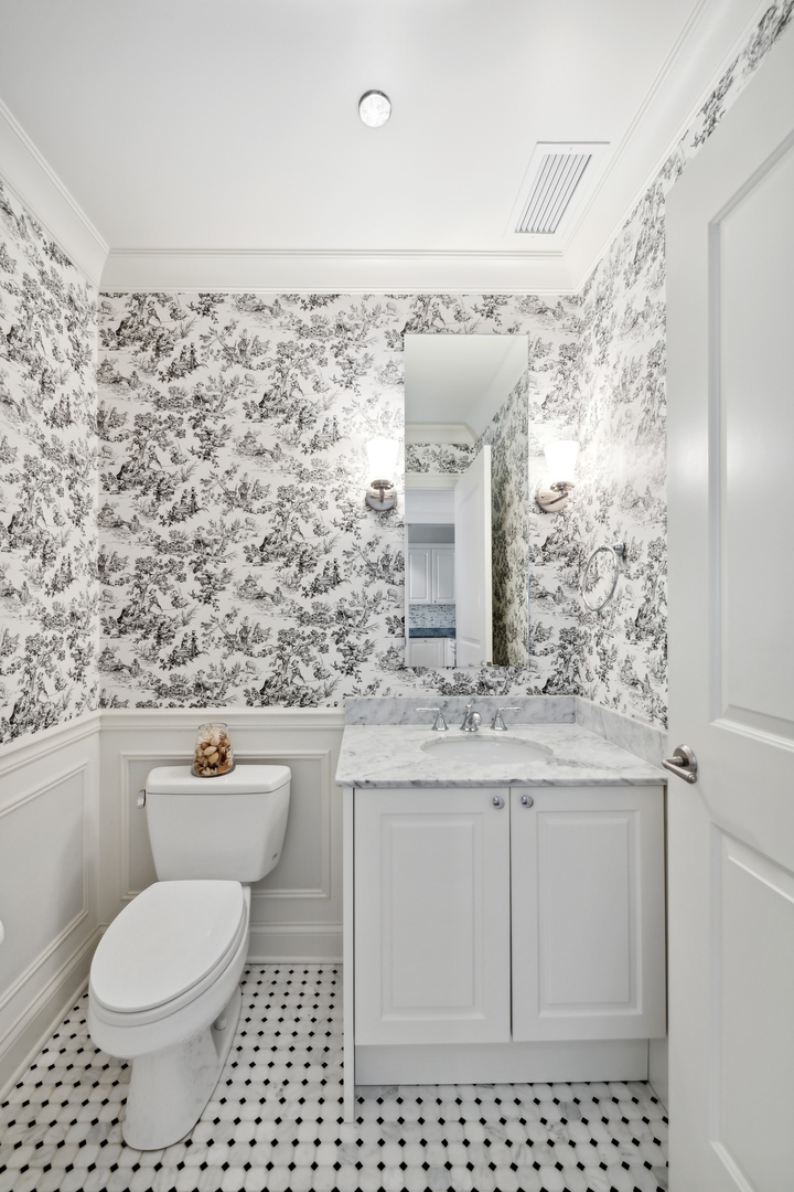 10 East Delaware Place, Unit 12E Chicago, IL 60611 - Photo 17 of 25 a bathroom with a granite countertop toilet a sink and a mirror
