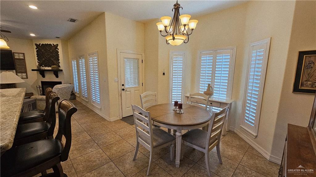 4711 North Stewart Road Palmhurst, TX 78573 - Photo 13 of 40 a view of a dining room with furniture and a chandelier