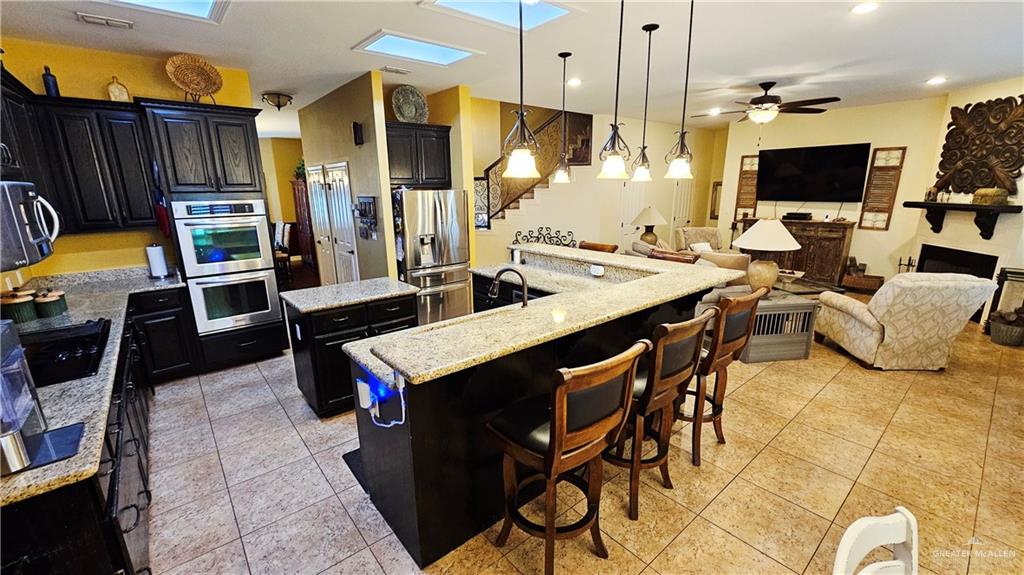4711 North Stewart Road Palmhurst, TX 78573 - Photo 14 of 40 a kitchen with stainless steel appliances kitchen island granite countertop a table and chairs