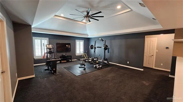 a view of a livingroom with workspace and a ceiling fan