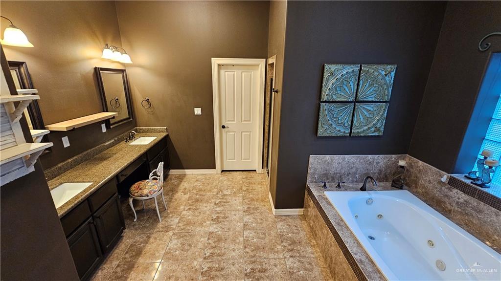 4711 North Stewart Road Palmhurst, TX 78573 - Photo 33 of 40 a bathroom with a granite countertop sink and a mirror