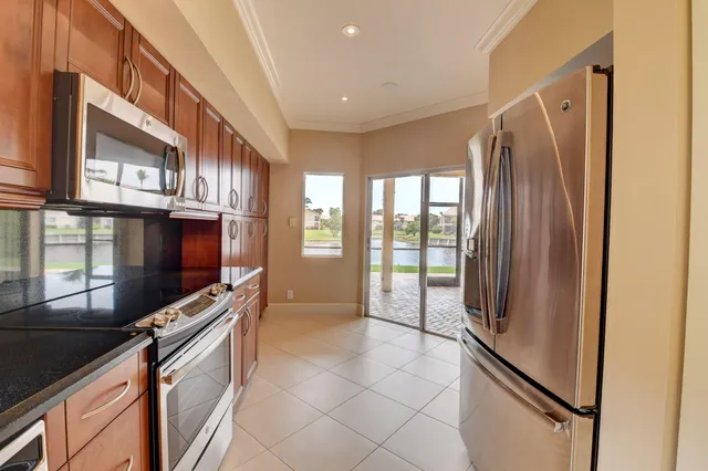 a kitchen with stainless steel appliances granite countertop a refrigerator a stove and a sink
