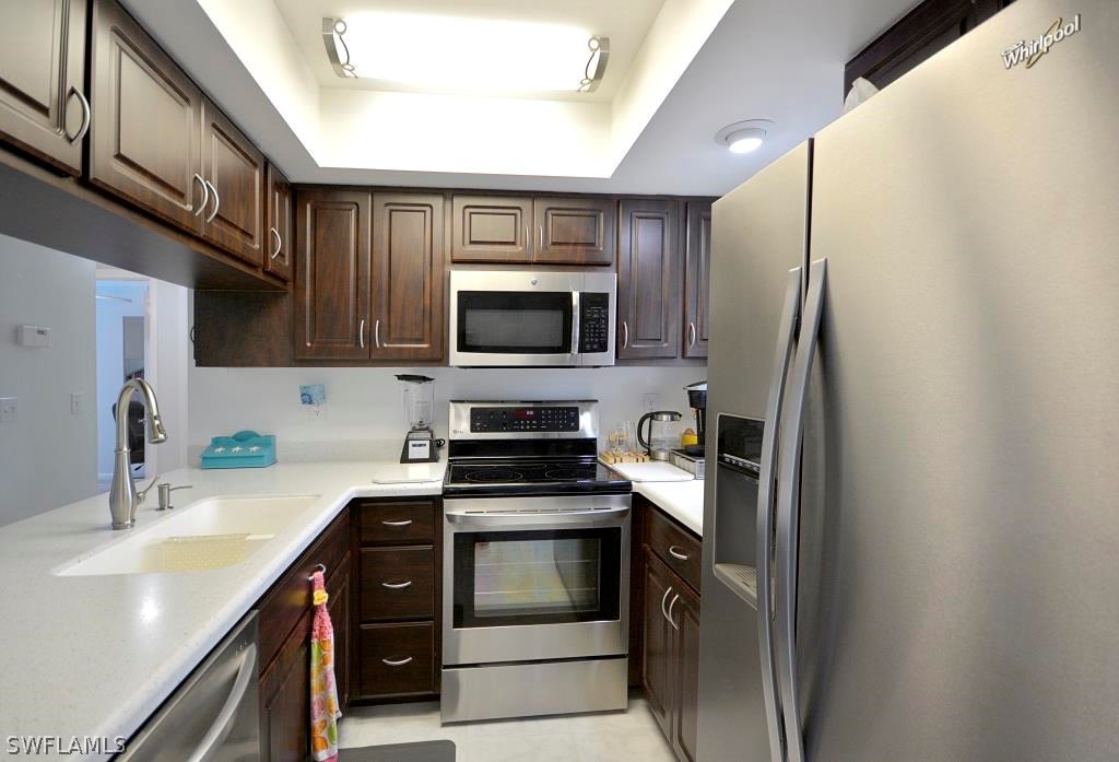 5919 Mackerel Road Bokeelia, FL 33922 - Photo 2 of 27 a kitchen with a sink stove and refrigerator