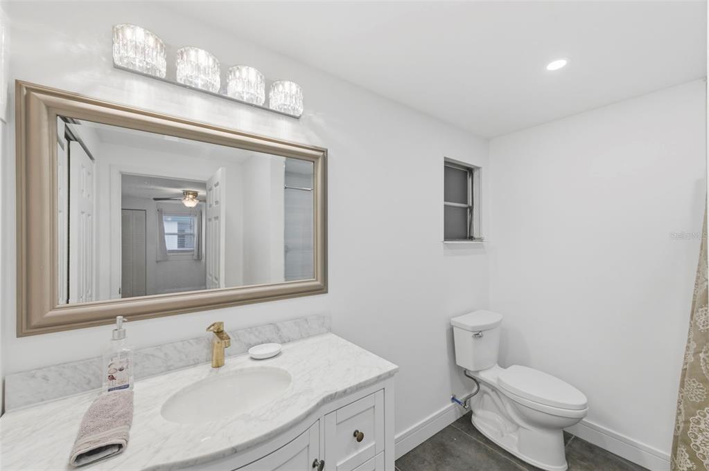 10810 Freedom Drive Port Richey, FL 34668 - Photo 26 of 65 a bathroom with a toilet sink and mirror