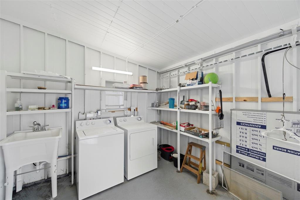 10810 Freedom Drive Port Richey, FL 34668 - Photo 30 of 65 a utility room with cabinets dryer and washer