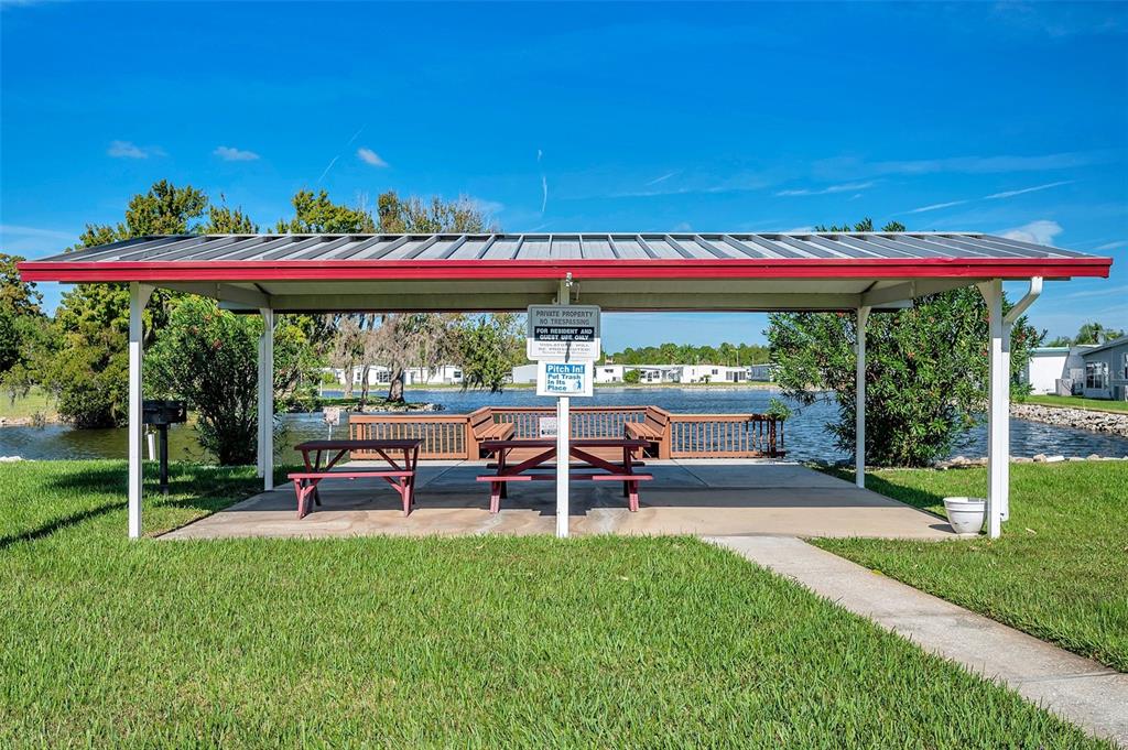 10810 Freedom Drive Port Richey, FL 34668 - Photo 57 of 65 a view of a swimming pool with a table and chairs under an umbrella