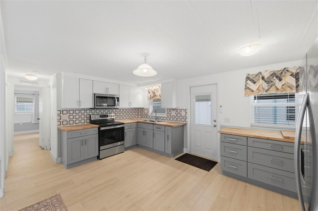 10810 Freedom Drive Port Richey, FL 34668 - Photo 8 of 65 a kitchen with stainless steel appliances kitchen island granite countertop a refrigerator and a stove top oven