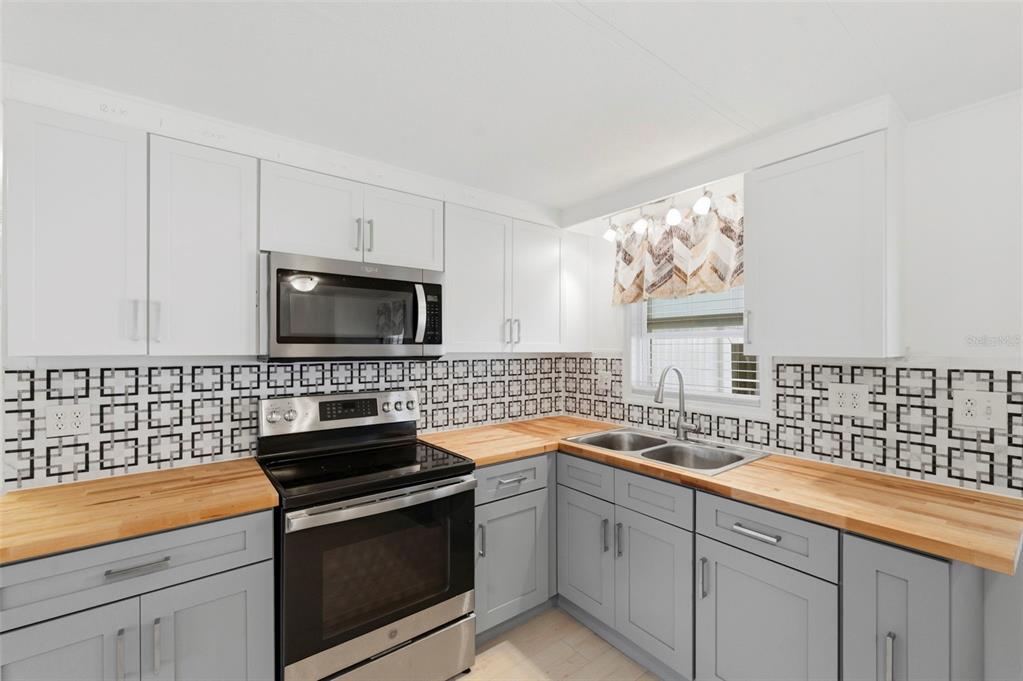 10810 Freedom Drive Port Richey, FL 34668 - Photo 10 of 65 a kitchen with a sink and stainless steel appliances