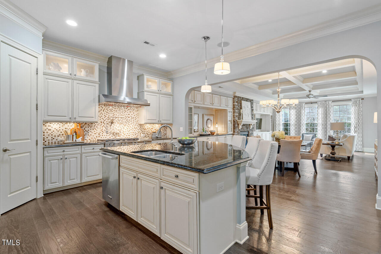 3841 Cottage Rose Lane Raleigh, NC 27612 - Photo 11 of 35 a kitchen with stainless steel appliances granite countertop a lot of counter space and wooden floors