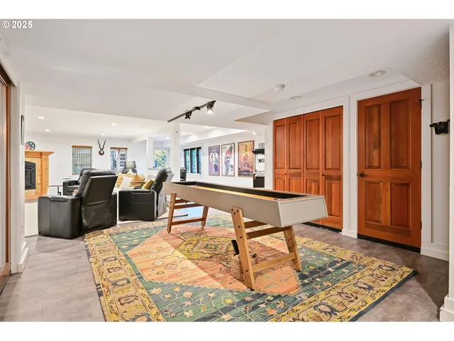 a living room with stainless steel appliances kitchen island granite countertop a table chairs and a refrigerator