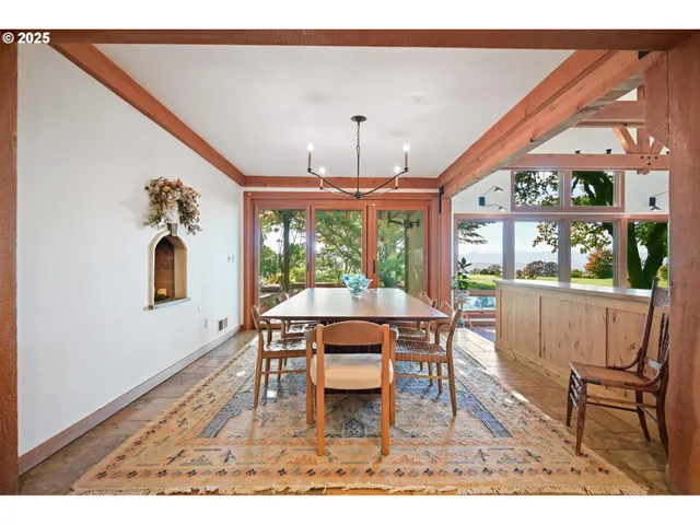 a living room with furniture large windows and wooden floor