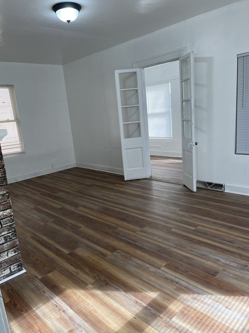 271 East 148th Street Harvey, IL 60426 - Photo 3 of 7 a view of an empty room with wooden floor and a window