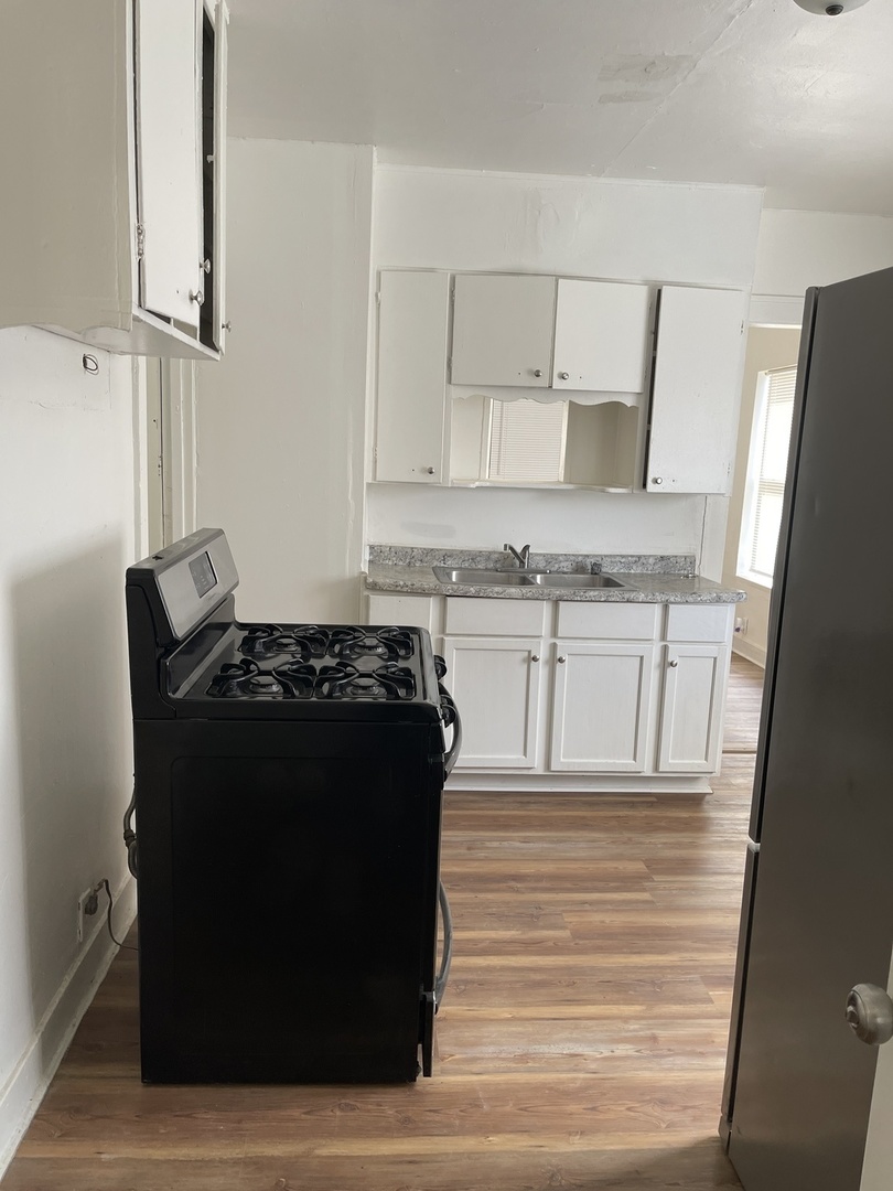 271 East 148th Street Harvey, IL 60426 - Photo 6 of 7 a kitchen with a stove and a refrigerator
