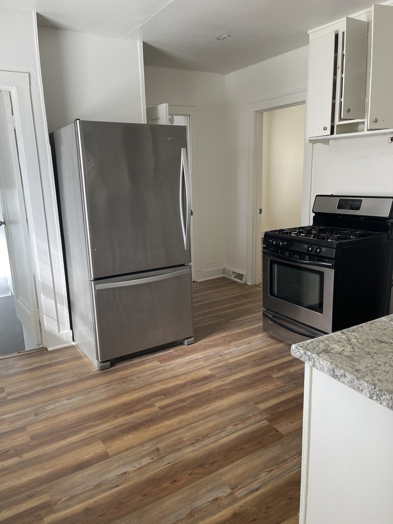 271 East 148th Street Harvey, IL 60426 - Photo 7 of 7 a kitchen with granite countertop a refrigerator stove and cabinets