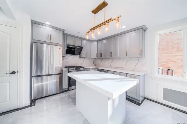 a kitchen with stainless steel appliances a stove a sink and a refrigerator