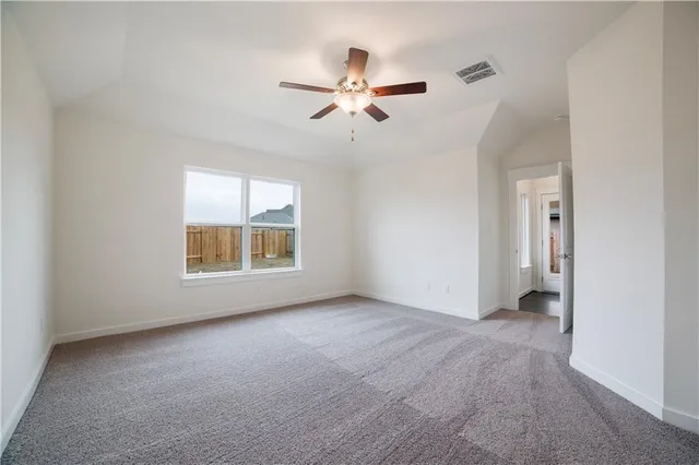 a view of empty room with window and ceiling fan