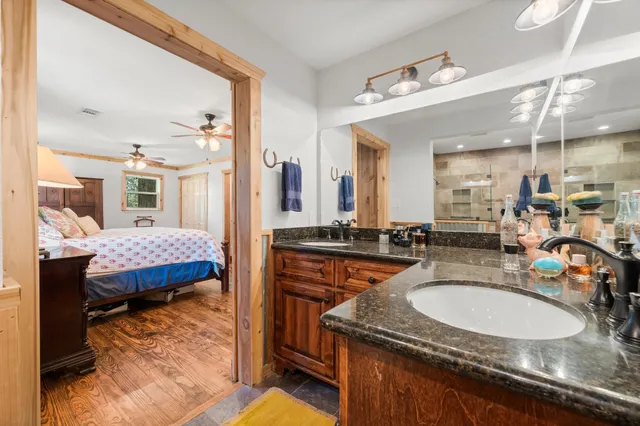 a en suite bathroom with a granite countertop sink and a mirror