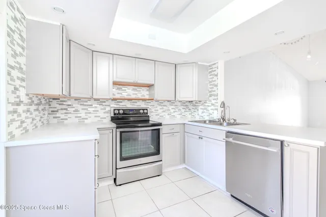 a kitchen with granite countertop white cabinets sink and stainless steel appliances