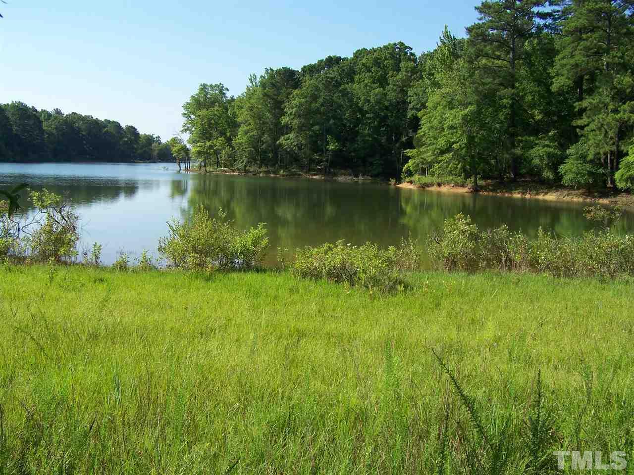 105 Rock Spring Church Road Henderson, NC 27537 - Photo 1 of 9 a view of a lake with a big yard and large trees
