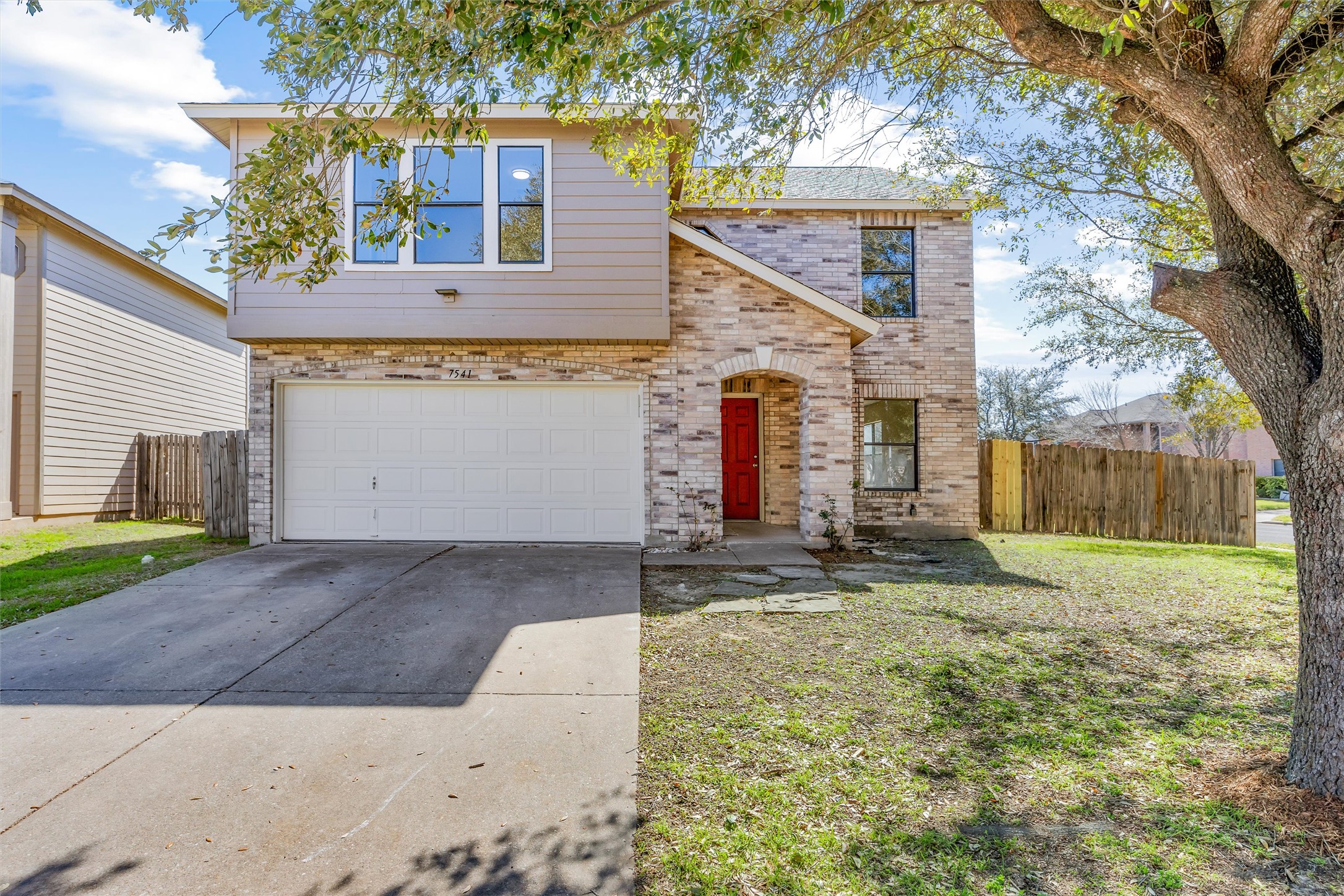 7541 Redrick Drive Austin, TX 78747 - Photo 1 of 40 View of front of property featuring concrete driveway, a garage, fence, and brick siding