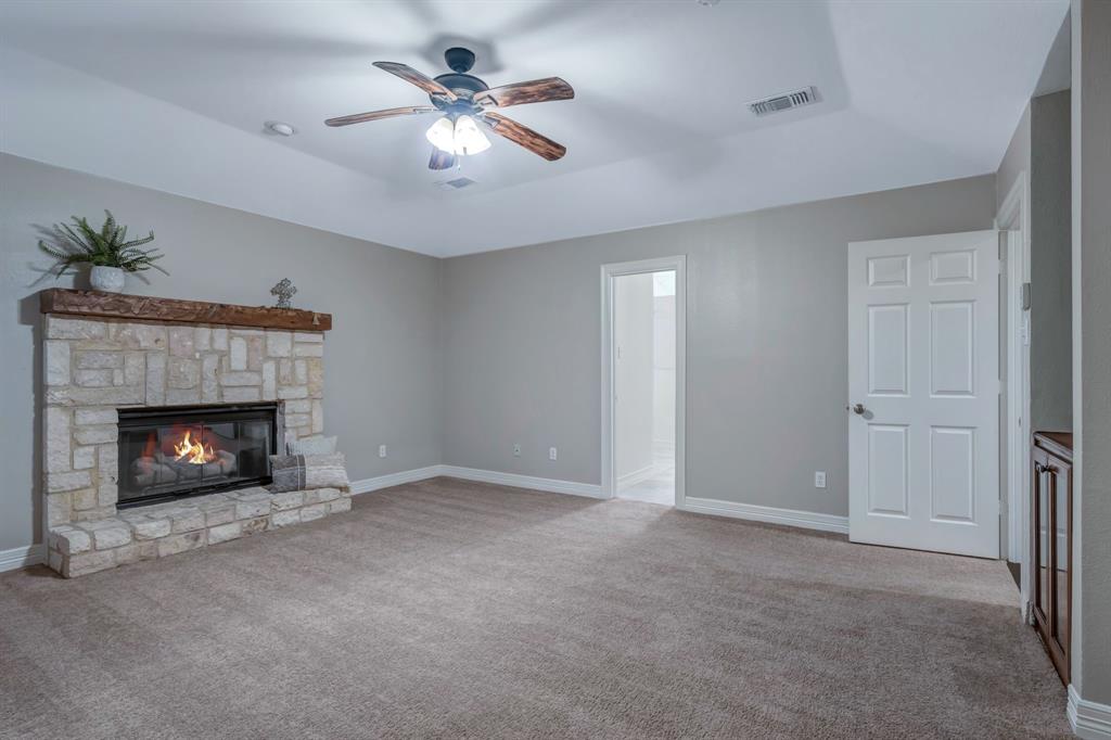 1810 Longbranch Road Waxahachie, TX 76065 - Photo 25 of 39 a view of an empty room with a fireplace and a ceiling fan