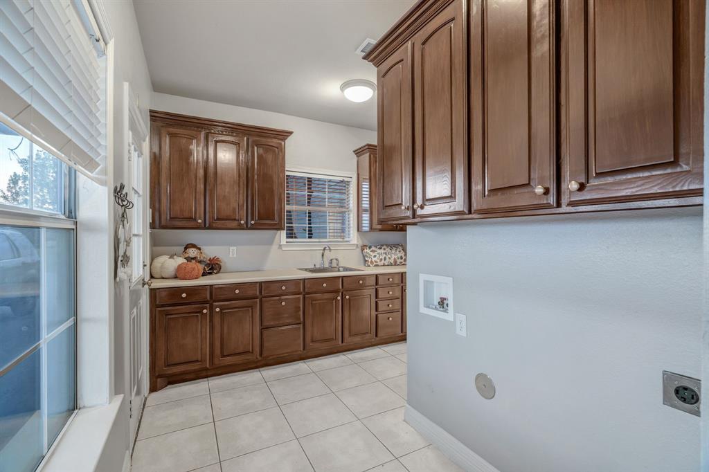 1810 Longbranch Road Waxahachie, TX 76065 - Photo 29 of 39 a kitchen with stainless steel appliances granite countertop a sink and dishwasher a refrigerator with wooden cabinets
