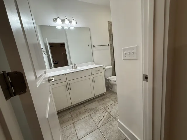 a bathroom with a sink a toilet and a mirror