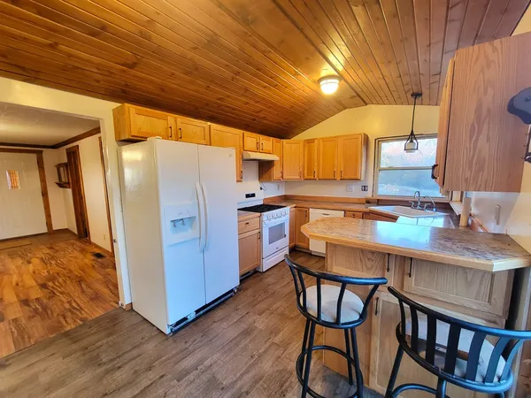 a kitchen with stainless steel appliances granite countertop a table chairs and a refrigerator