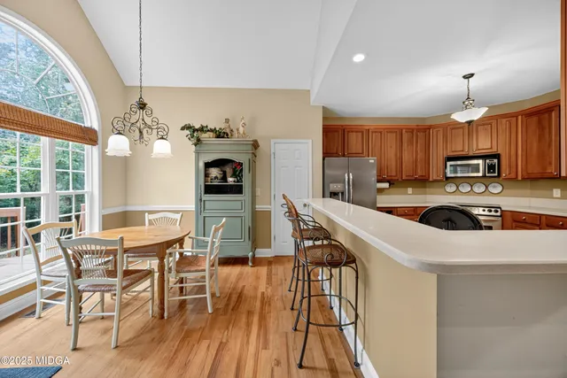 a kitchen with a table chairs microwave and refrigerator