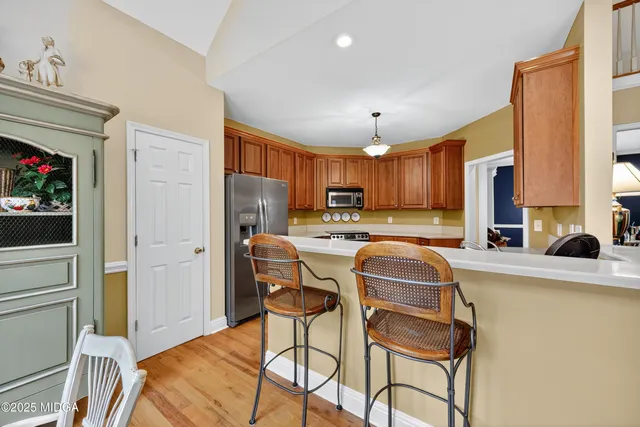 a kitchen with stainless steel appliances granite countertop a refrigerator and a stove top oven