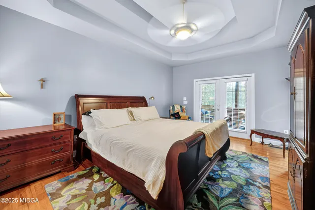 a bed sitting in a bedroom next to a window with a chandelier