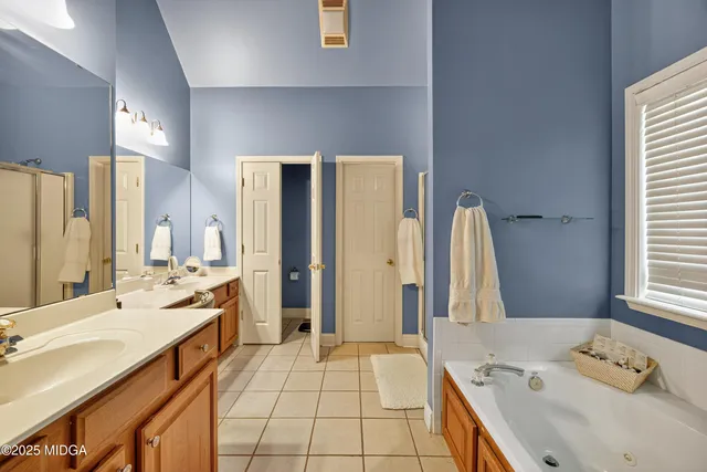 a spacious bathroom with a double vanity sink a mirror and a shower