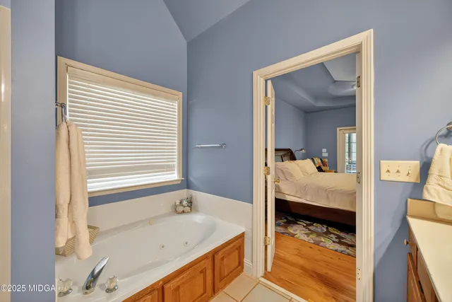 a en suite bathroom with a tub and a large mirror