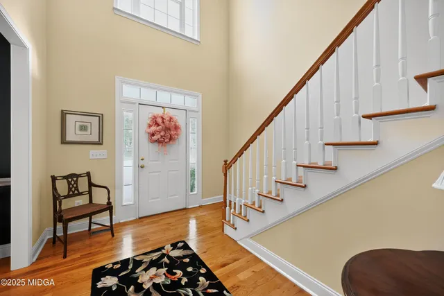 a hallway with wooden floor and stairs