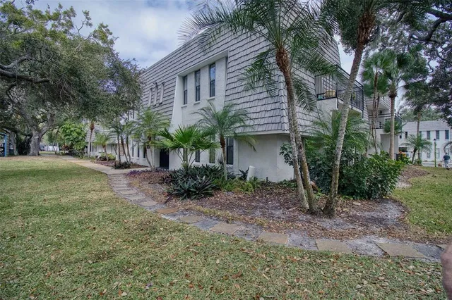 a view of a house with a yard and tree