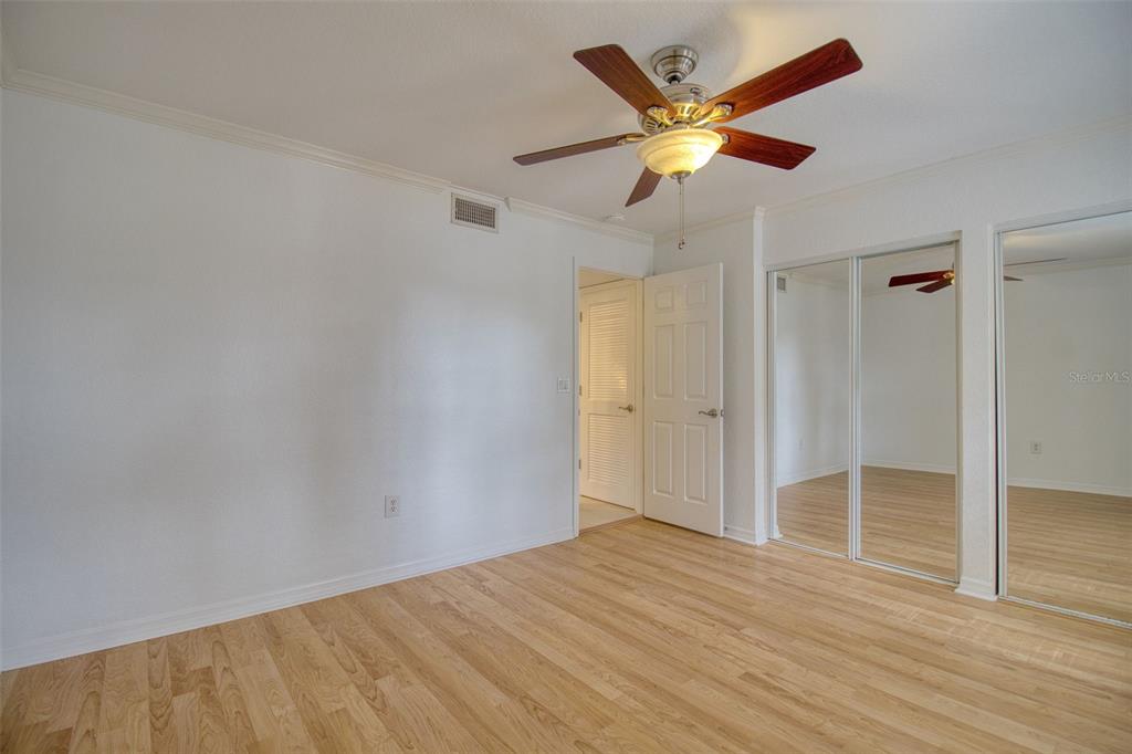 702 Lyndhurst Street, Unit 821 Dunedin, FL 34698 - Photo 16 of 30 an empty room with wooden floor and ceiling fan