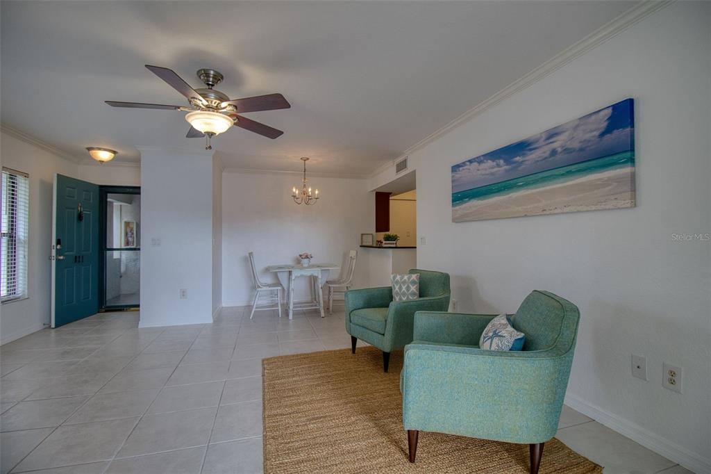 702 Lyndhurst Street, Unit 821 Dunedin, FL 34698 - Photo 6 of 30 a living room with furniture and a chandelier