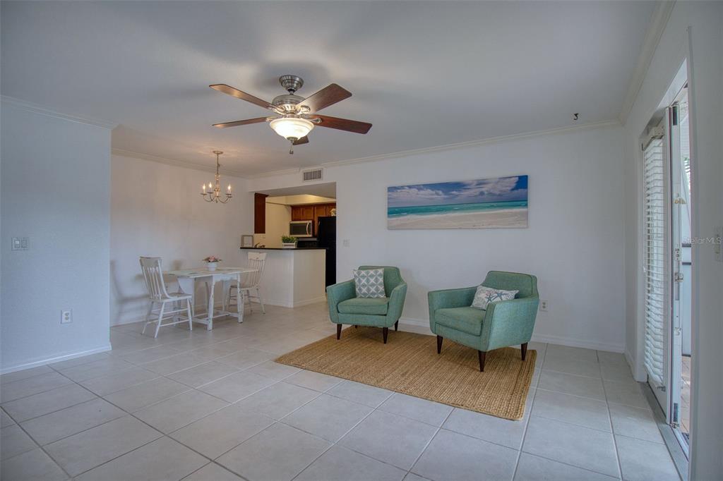 702 Lyndhurst Street, Unit 821 Dunedin, FL 34698 - Photo 7 of 30 a living room with furniture and a chandelier
