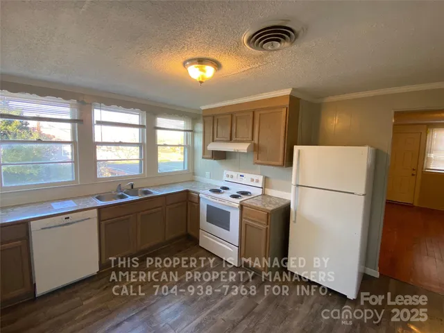 a kitchen with a refrigerator a stove a sink and a window