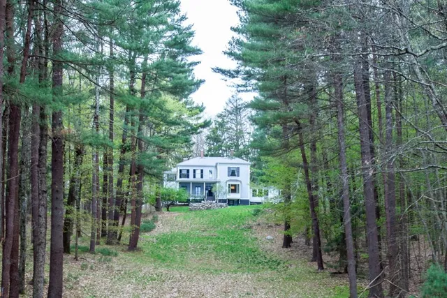 a view of a house with a yard and sitting area