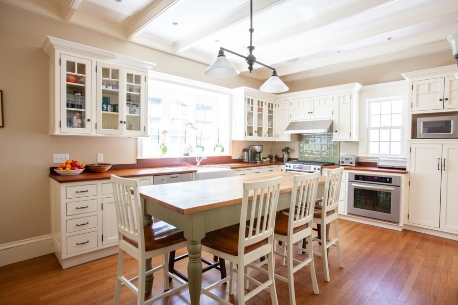 62 Pond Road Wellesley, MA 02482 - Photo 3 of 14 a kitchen with stainless steel appliances kitchen island granite countertop a stove a refrigerator a kitchen island with a stove and white cabinets