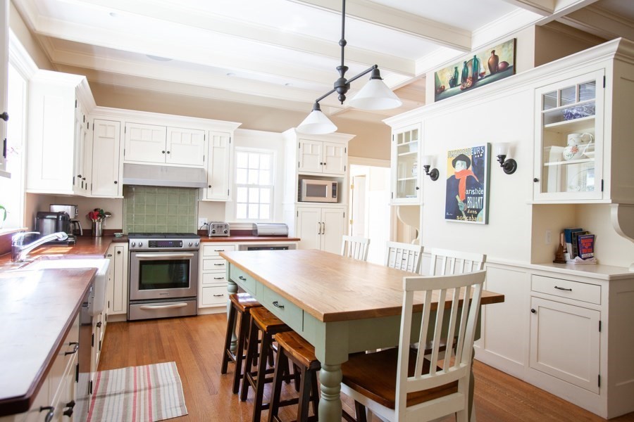 62 Pond Road Wellesley, MA 02482 - Photo 4 of 14 a kitchen with stainless steel appliances granite countertop a stove top oven a sink a dining table and chairs with wooden floor