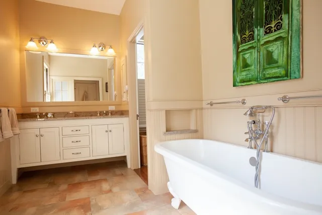 a bathroom with a tub sink and mirror