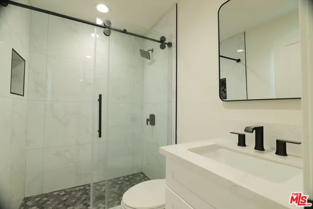 a bathroom with a sink a toilet and shower