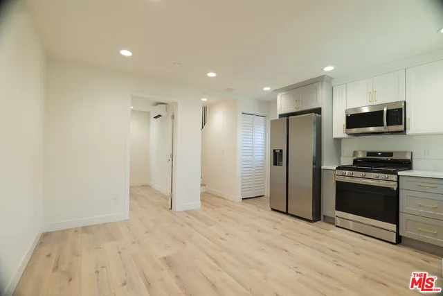 a kitchen with stainless steel appliances a refrigerator and a stove top oven