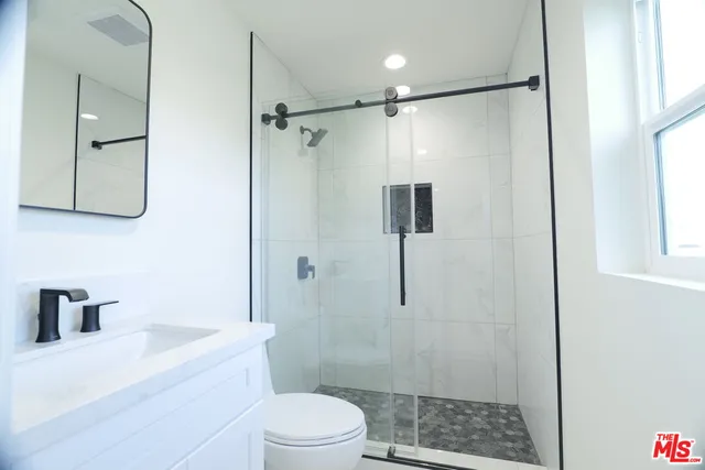 a bathroom with a shower a toilet and a sink