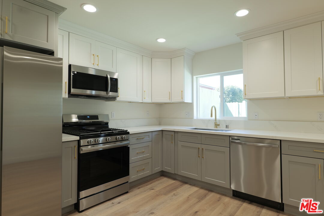 1338 West 30th Street Los Angeles, CA 90007 - Photo 3 of 21 a kitchen with a sink stove and microwave