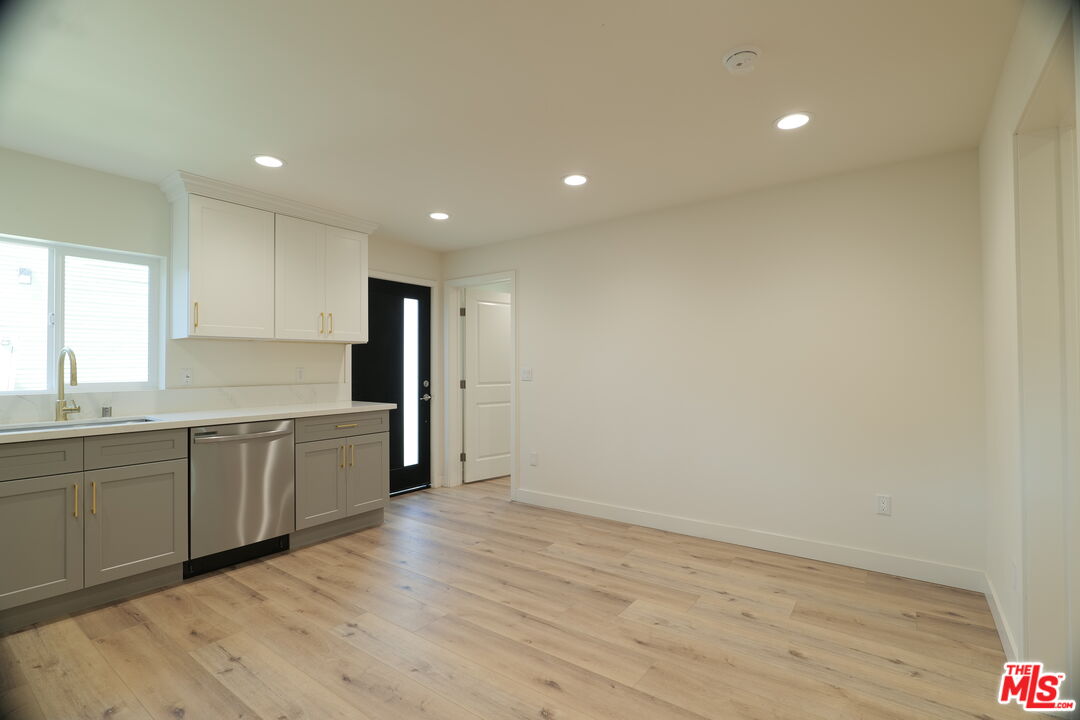 1338 West 30th Street Los Angeles, CA 90007 - Photo 4 of 21 a large kitchen with stainless steel appliances granite countertop a large counter top and a wooden floor